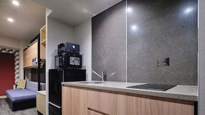 A compact kitchenette with a microwave, refrigerator, and sink. - MONday Apart Hamamatsucho Daimon (Tokyo)