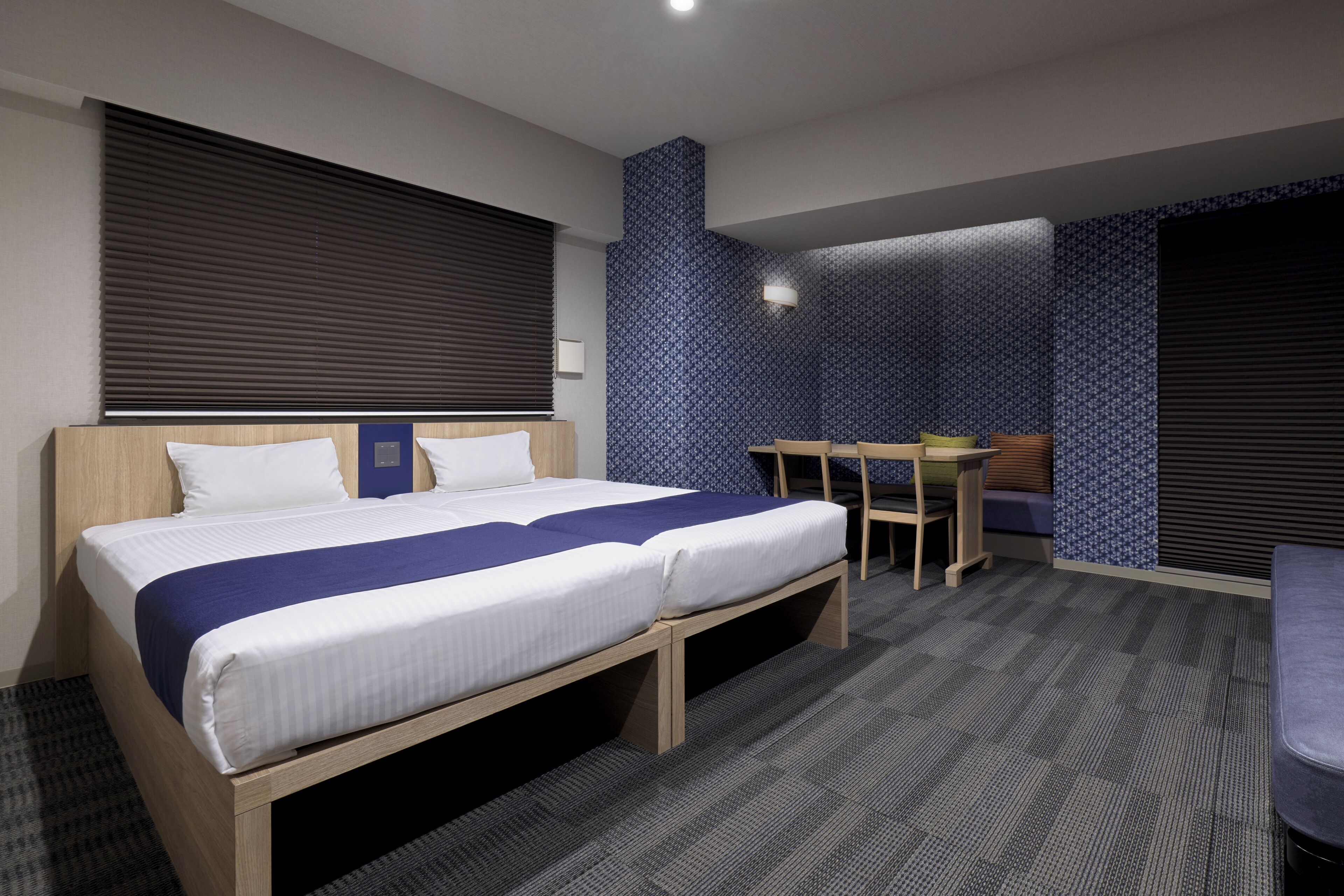 Une chambre d’hôtel avec un lit double, un bureau et une chaise.