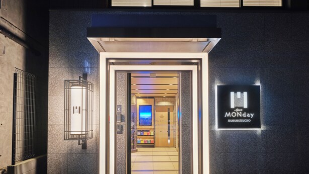 A hotel entrance with a modern design, a signboard, and a visible interior through the doorway. - MONday Apart Premium Hamamatsucho (Tokyo)