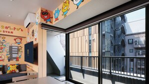 A hotel room with a large window, a staircase, and colorful wall decorations. - MONday Apart Premium Hamamatsucho (Tokyo)