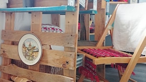 A rustic wooden table with a blue top, a woven basket, and a chair with a red and black patterned cushion. - Longjumeau Chambres d'Hôtes - Book A Rest Paris (Longjumeau)