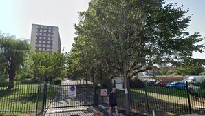A fenced park area with a pedestrian path, a dog, and a person walking a dog. - Longjumeau Chambres d'Hôtes - Book A Rest Paris (Longjumeau)