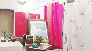 A bathroom with a white sink, a mirror, a framed picture, a potted plant, and a shower curtain with the word "BATH" printed on it. - Longjumeau Chambres d'Hôtes - Book A Rest Paris (Longjumeau)