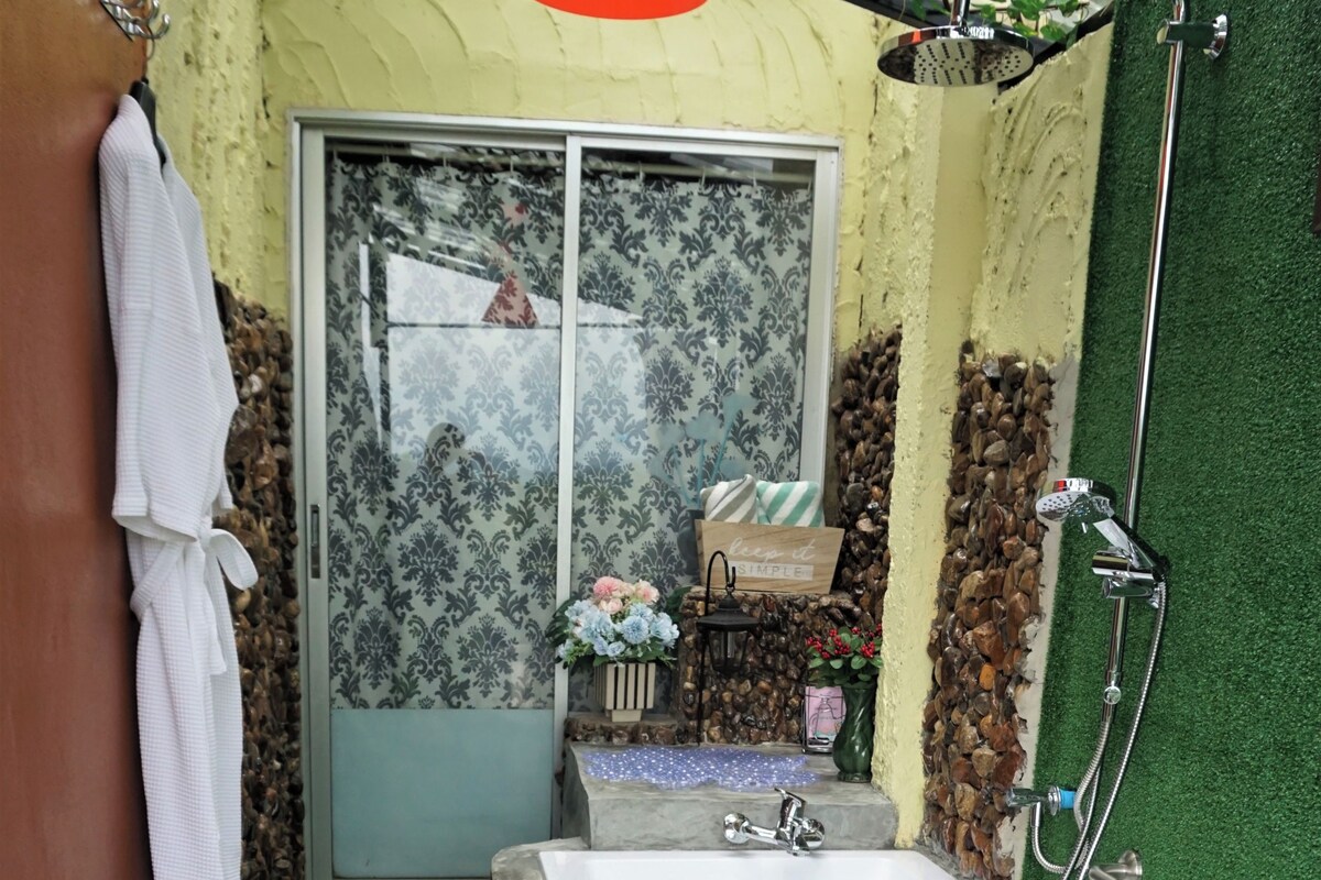 A bathroom with a large bathtub, a shower, and a window with a view.