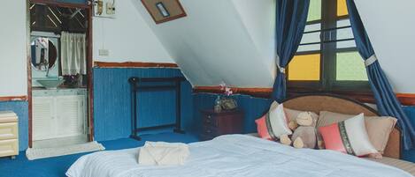 Un dormitorio con cama, cómoda, espejo y ventana con cortinas.