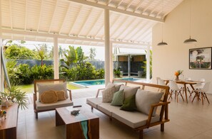 A spacious living area with a pool, outdoor seating, and a dining area. - Good Story Village (Ahangama)