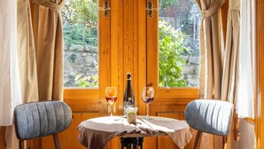 Une table à manger avec deux chaises, une bouteille de vin et deux verres à vin.