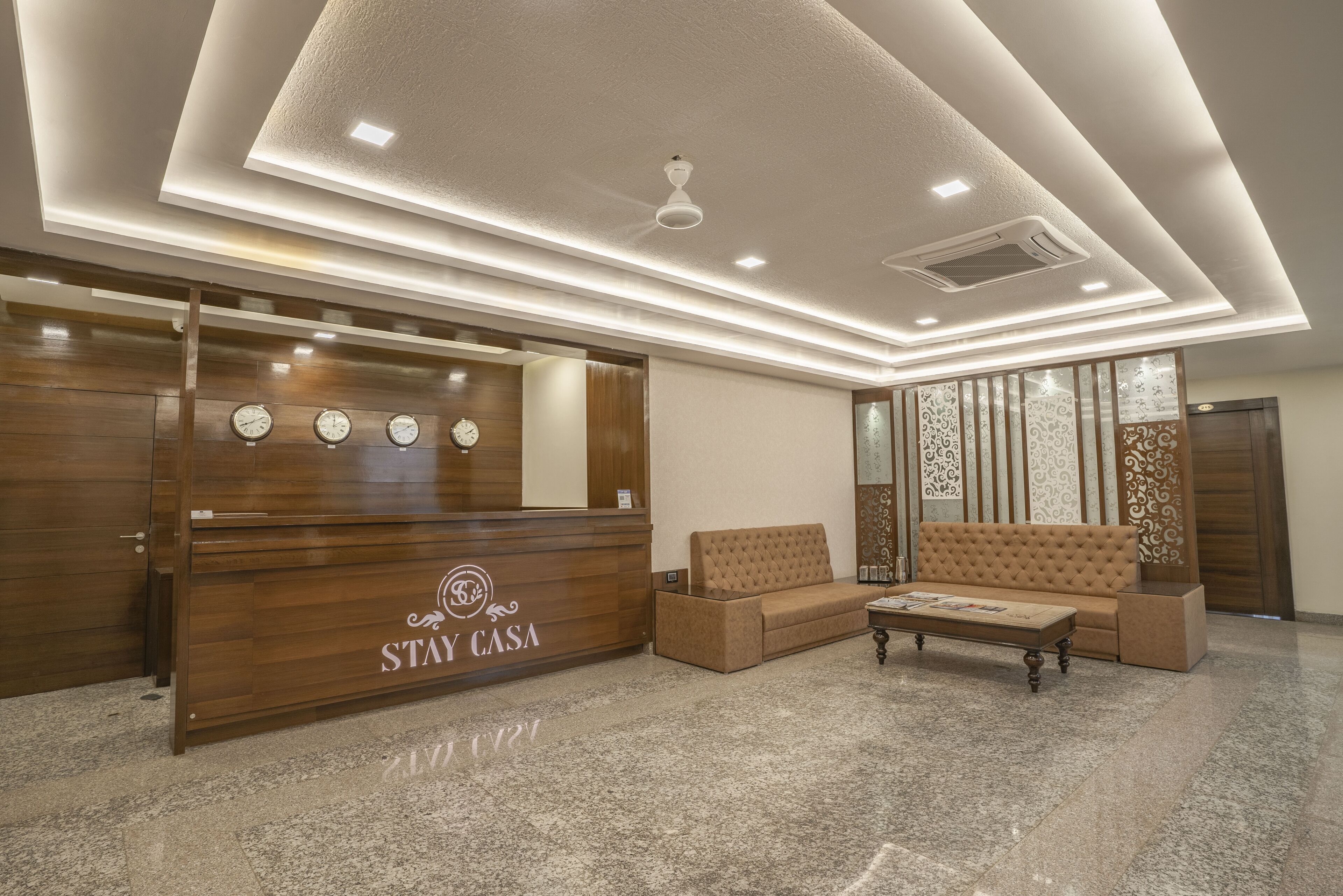 A reception area with a wooden reception desk, a sofa, and a coffee table.