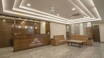 A reception area with a wooden reception desk, a sofa, and a coffee table.