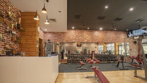 Un gimnasio con paredes de madera, un mostrador de recepción y diverso equipamiento de ejercicio.