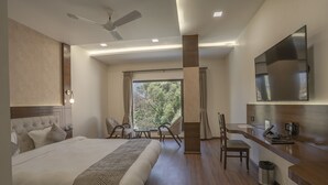 Una habitación de hotel moderna con una cama grande, un escritorio y una televisión.