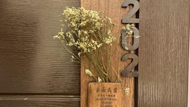 A wooden plaque with the word "HOME" and a small wooden box with dried flowers and text. - Yung Cheng (Jinhu)
