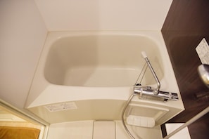 A white bathtub with a handheld showerhead and a control panel. - Asakusa Hotel 303 (Tokyo)