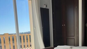 A hotel room with a large bed, a wardrobe, and a view of the city through a large window. - Villa Zoe - 4 bed - sleeps 8 - sea views - BOOK NOW!!!! (Benitachell, Alicante)