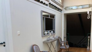 Ein geräumiger Raum mit Glasboden, Holzmöbeln und einem Fenster mit dekorativem Spiegel.