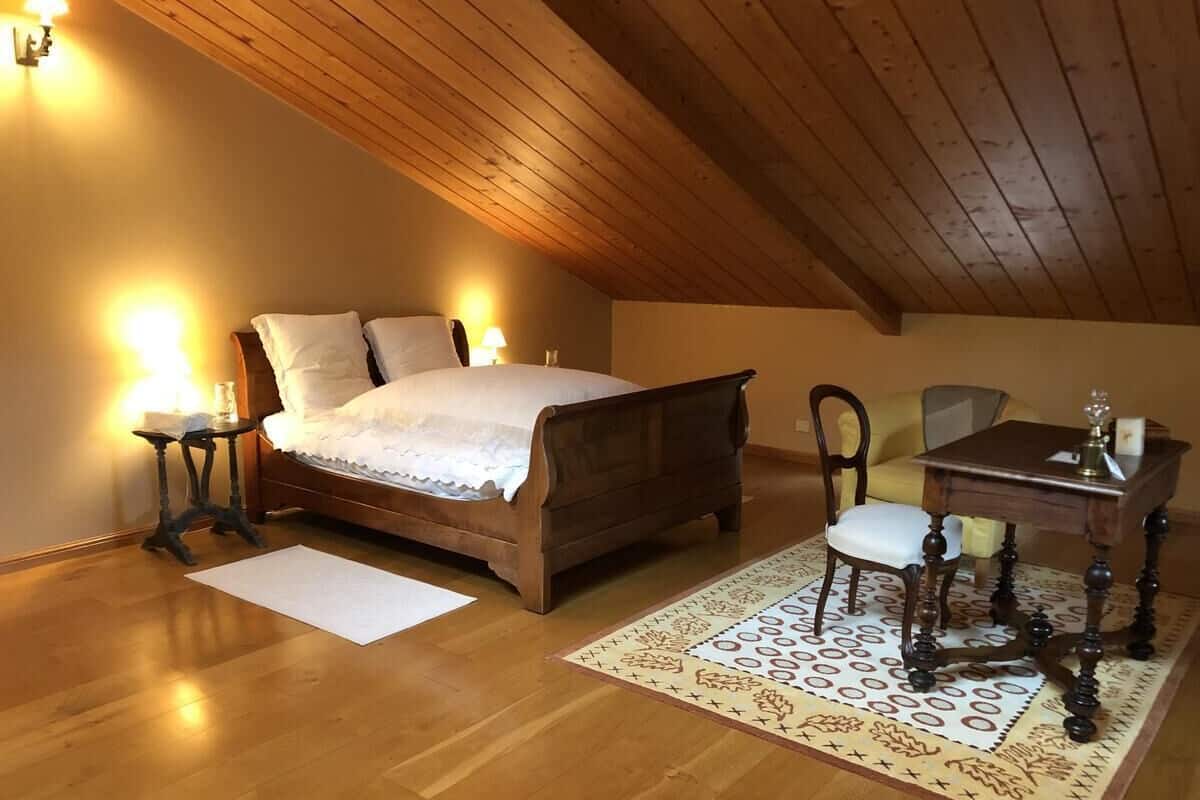 Une chambre à coucher avec un lit en bois, des tables de chevet, un bureau et une chaise.
