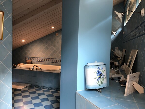 Un baño con piso a cuadros, una bañera y un lavamanos con grifo.