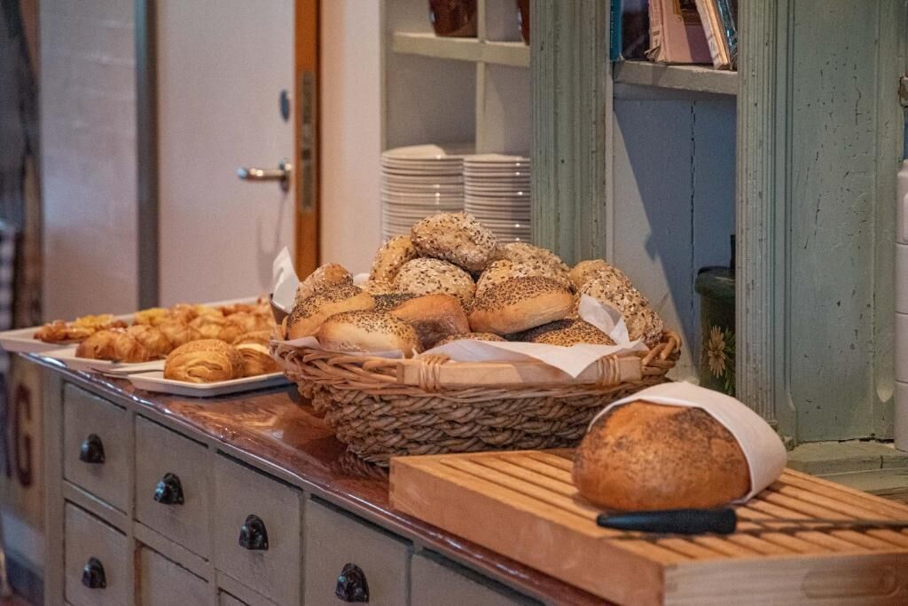 Una mesa de buffet con panes y pasteles varios.