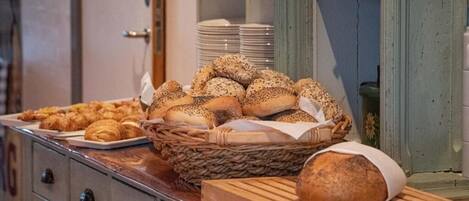 A buffet table with various breads and pastries.
