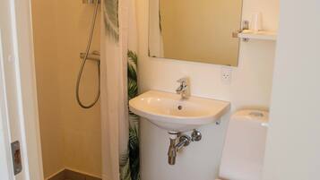 A bathroom with a shower, sink, and toilet.