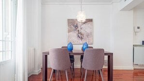 Uma sala de jantar com uma mesa de madeira, duas cadeiras e um lustre.