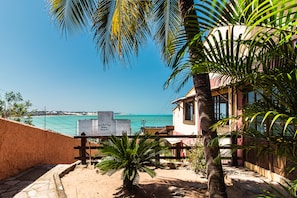 A coastal view with a sign for "Ibiza Beach" and a building with a red facade.