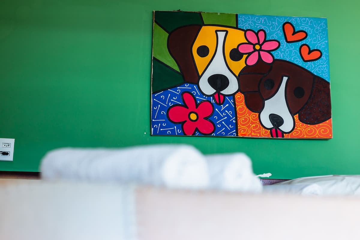 A painting of two dogs on a green wall.