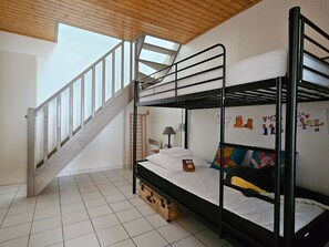 A bunk bed room with a wooden staircase and a window.
