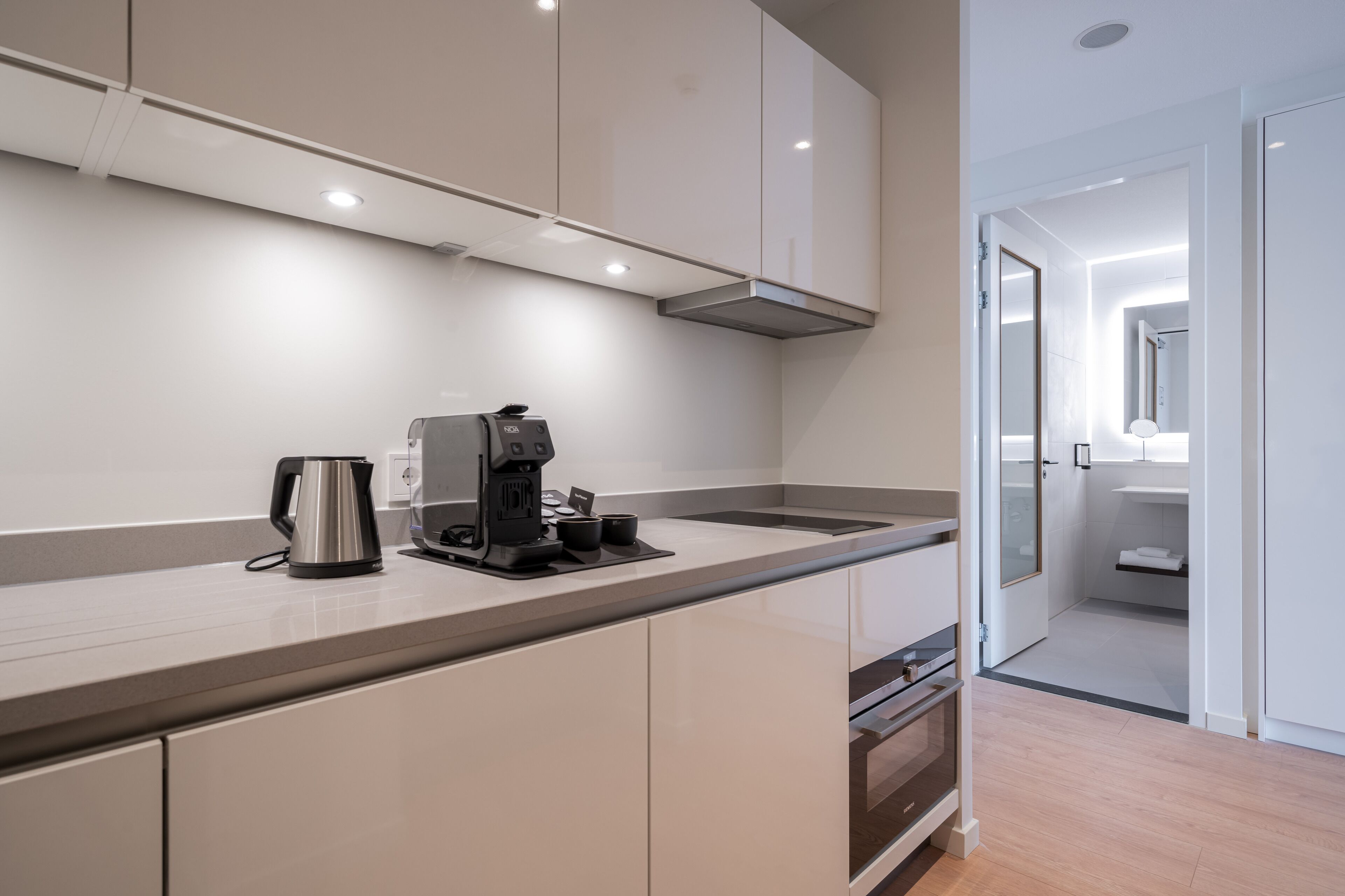 Una cocina moderna con horno integrado, cafetera y una encimera elegante.