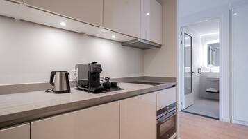 Una cocina moderna con horno integrado, cafetera y una encimera elegante.