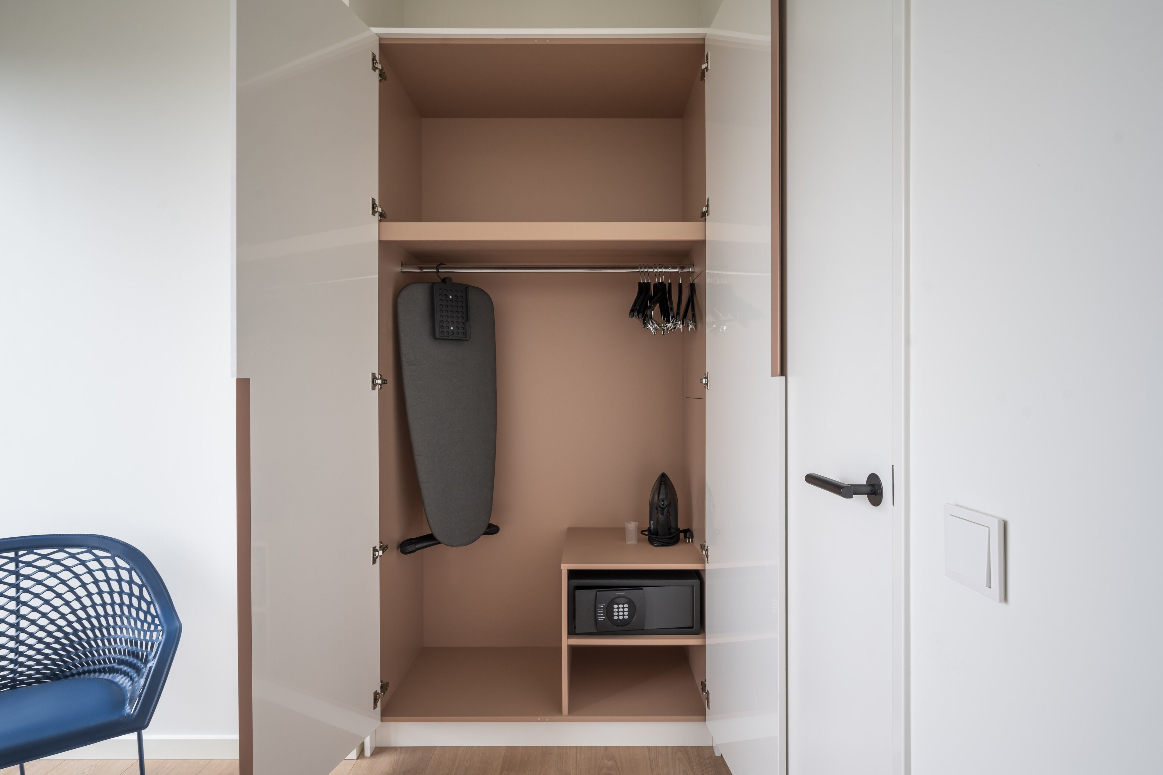 Un vestidor con espacio para colgar, un microondas y un estante pequeño.
