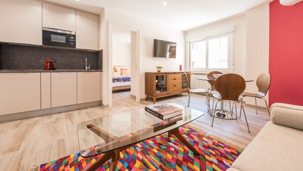 Un appartement moderne comprenant une cuisine, un coin repas et un salon.