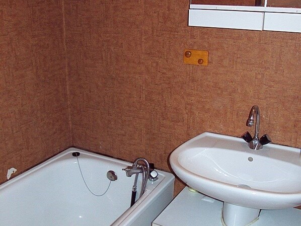 Une salle de bain avec une baignoire et un lavabo.