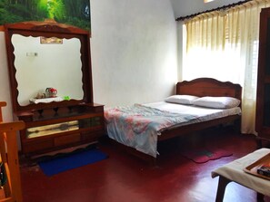Cozy bedroom with a comfortable bed, dresser, and mirror.