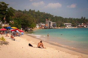 Relax under the shade of beach umbrellas and enjoy a social atmosphere near nearby accommodations.