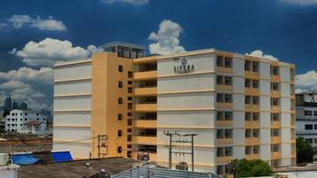 A multi-story building with the name "SITARA" on the facade, featuring balconies and a rooftop terrace.