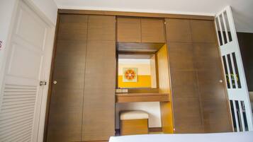 Un dormitorio con un armario de madera, un pequeño banco y un adorno de pared decorativo.