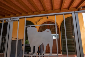 A building entrance with a metal gate, a yellow wall, and a sign that reads "Al Castillo".