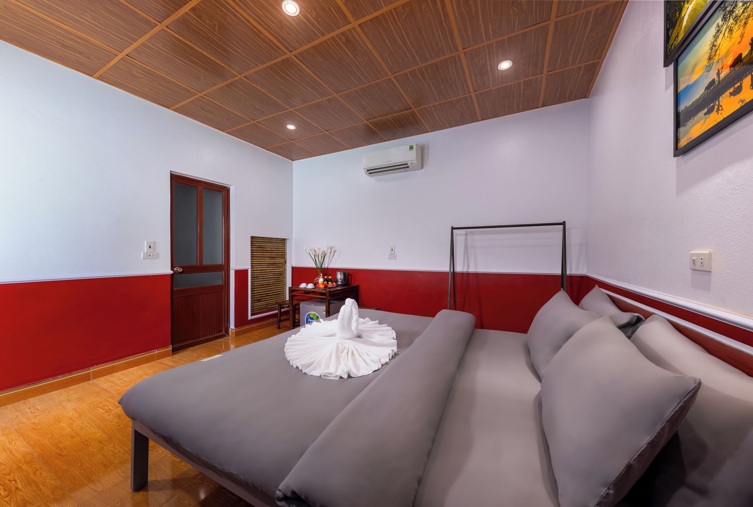 Quarto com cama, teto de madeira, ar condicionado e porta.
