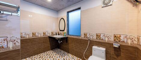 Ein Badezimmer mit Toilette, Waschbecken, Spiegel und dekorativen Fliesen.