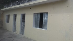 Un edificio con tres ventanas, cada una con contraventanas.