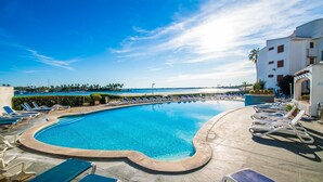 A swimming pool with lounge chairs and a view of the sea. - Luxury apartment Blue Sea in Alcudia beachview (Alcúdia)