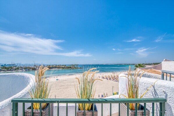 A beach view with a clear sky, a sandy beach, and a calm sea.