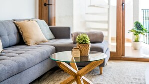 A modern living room with a grey sofa, a glass coffee table, and a small potted plant. - Luxury apartment Blue Sea in Alcudia beachview (Alcúdia)