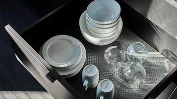 A tray with stacked plates and clear glassware.