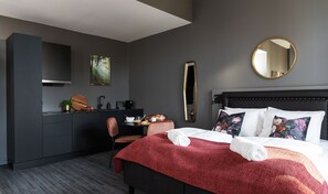 Una habitación de hotel moderna con cama, escritorio y una silla.