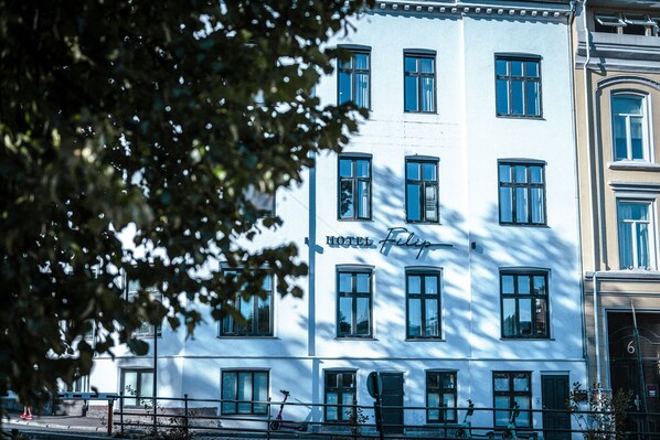 A white building with multiple windows and a sign that reads "HOTEL". - Hotel Filip (Oslo)