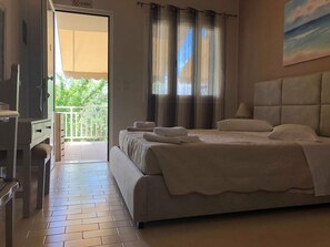 A bedroom with a bed, a TV, and a balcony.