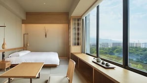 A modern bedroom with a large window, a bed, a desk, and a chair. - Onsen Ryokan Yuen Sapporo (Sapporo)
