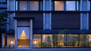 A modern building with multiple floors, large windows, and a well-lit entrance. - Onsen Ryokan Yuen Sapporo (Sapporo)